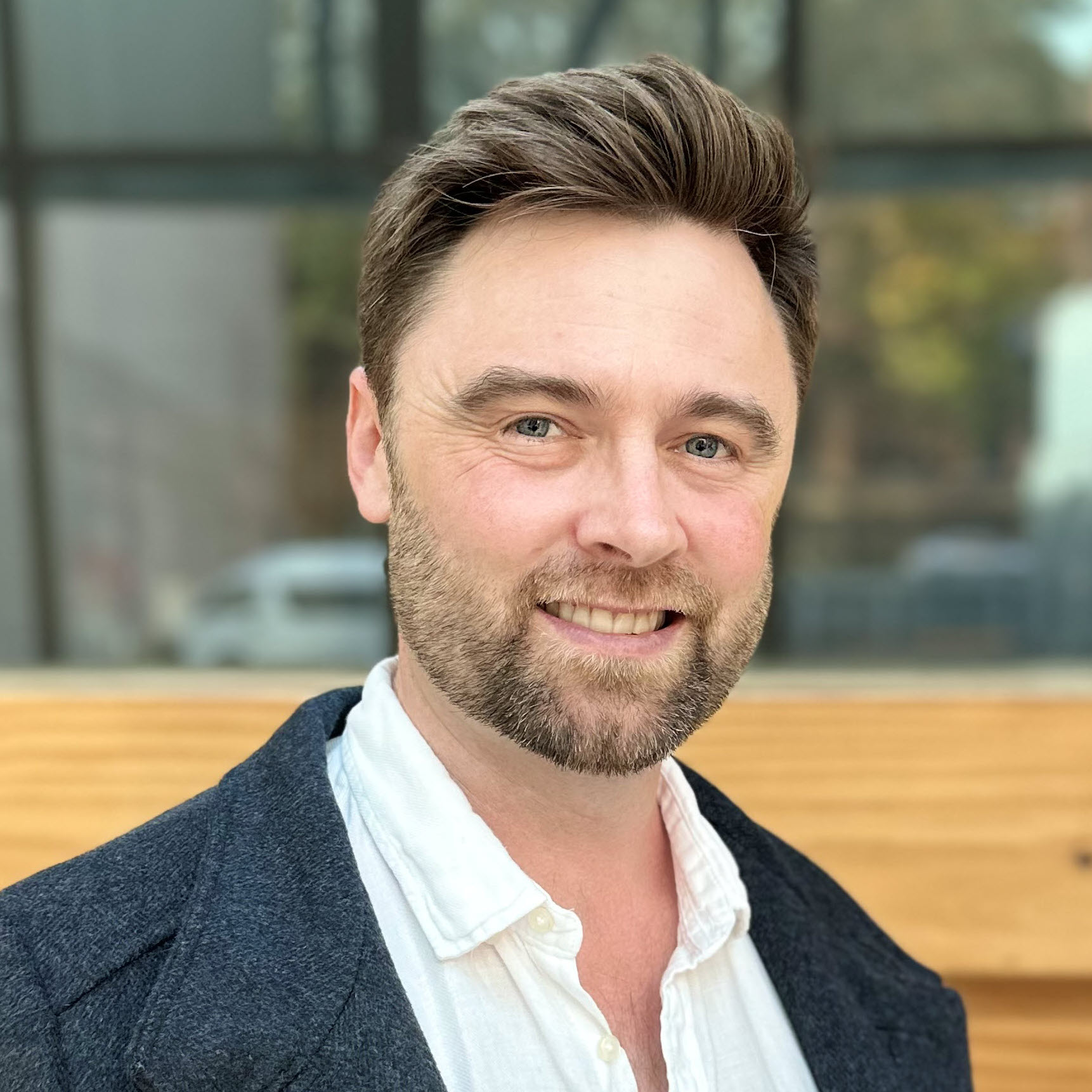 Kieran Morgan smiling toward the camera in a head-and-shoulders portrait